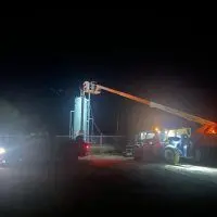 Boom lift lighting up an oilfield separator at night